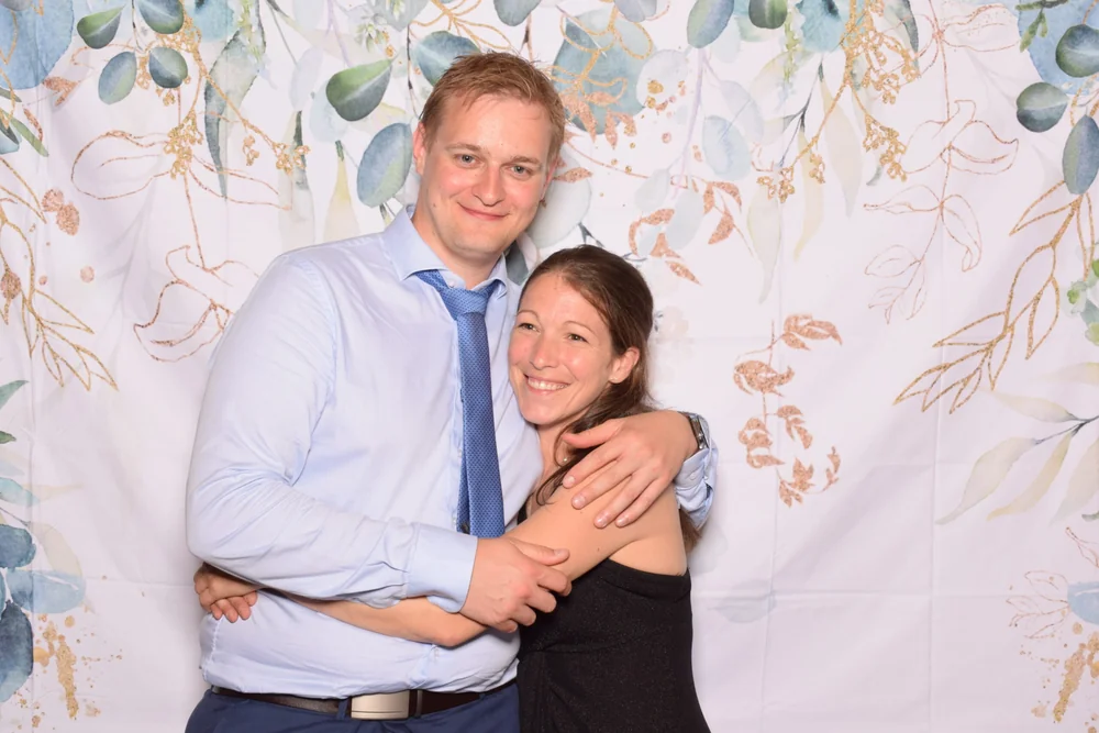 A couple posing together in front of the photobooth